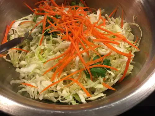 Add all the fresh ingredients into the bowl (carrots, cabbage, cilantro), add some salt to start to soften the vegetables and draw out some of the liquid